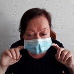 Dedos índices tirando levemente hacia adelante la mascarilla al nivel de la boca.